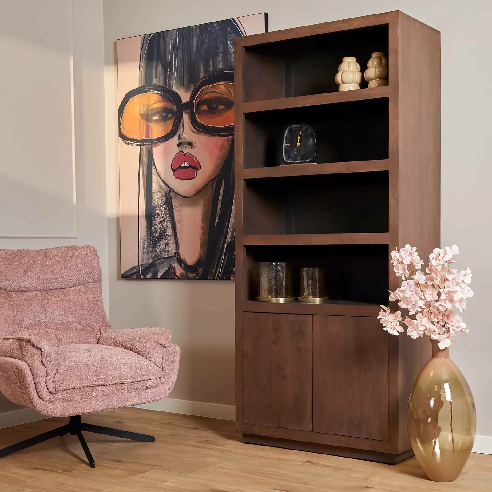 Roze fauteuil met een donkerbruine boekenkast en een schilderij van een vrouw met zonnebril - Starfurn