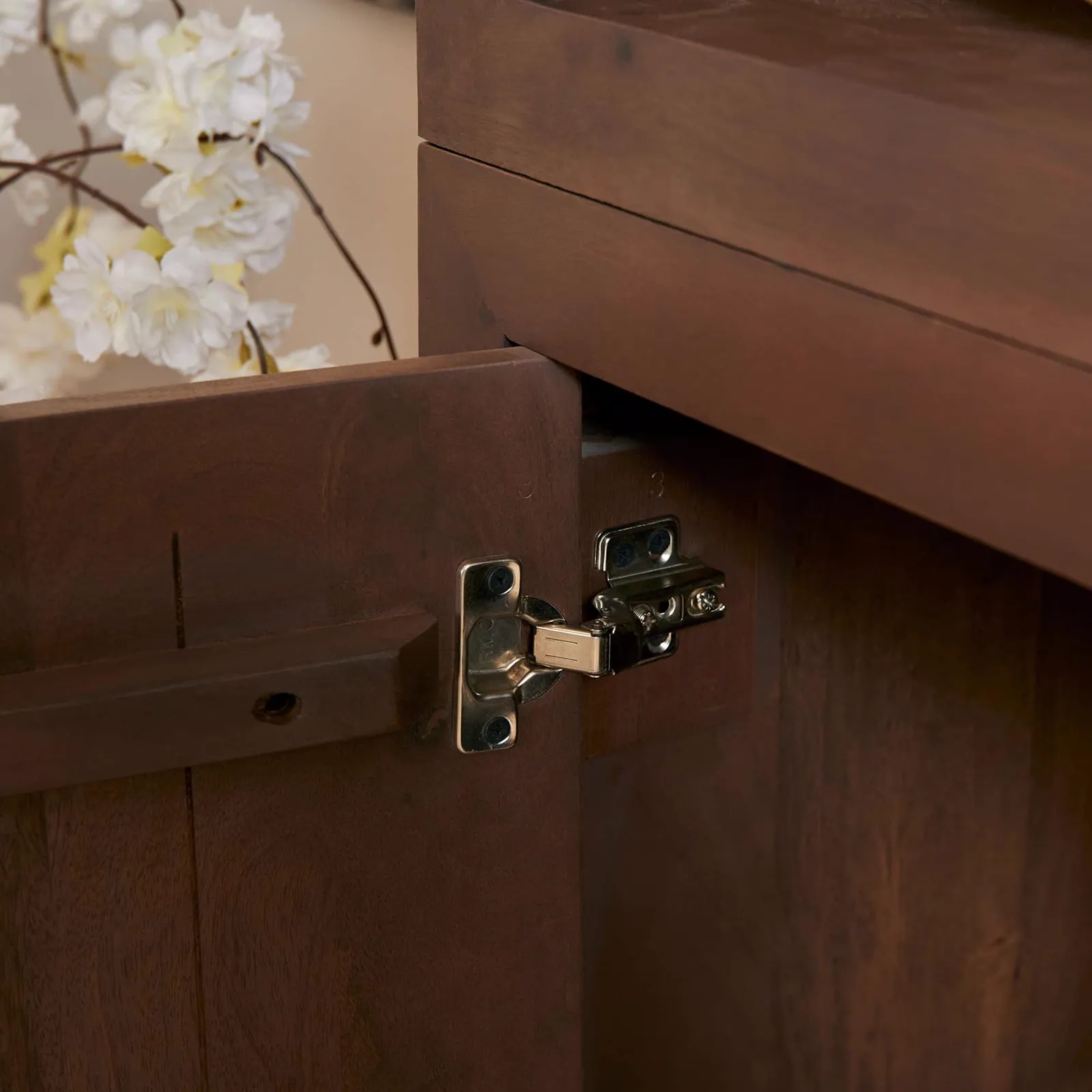 Detailopname van de Salontafel Brussel Walnut, met een openstaand kastdeurtje en scharnier - Starfurn
