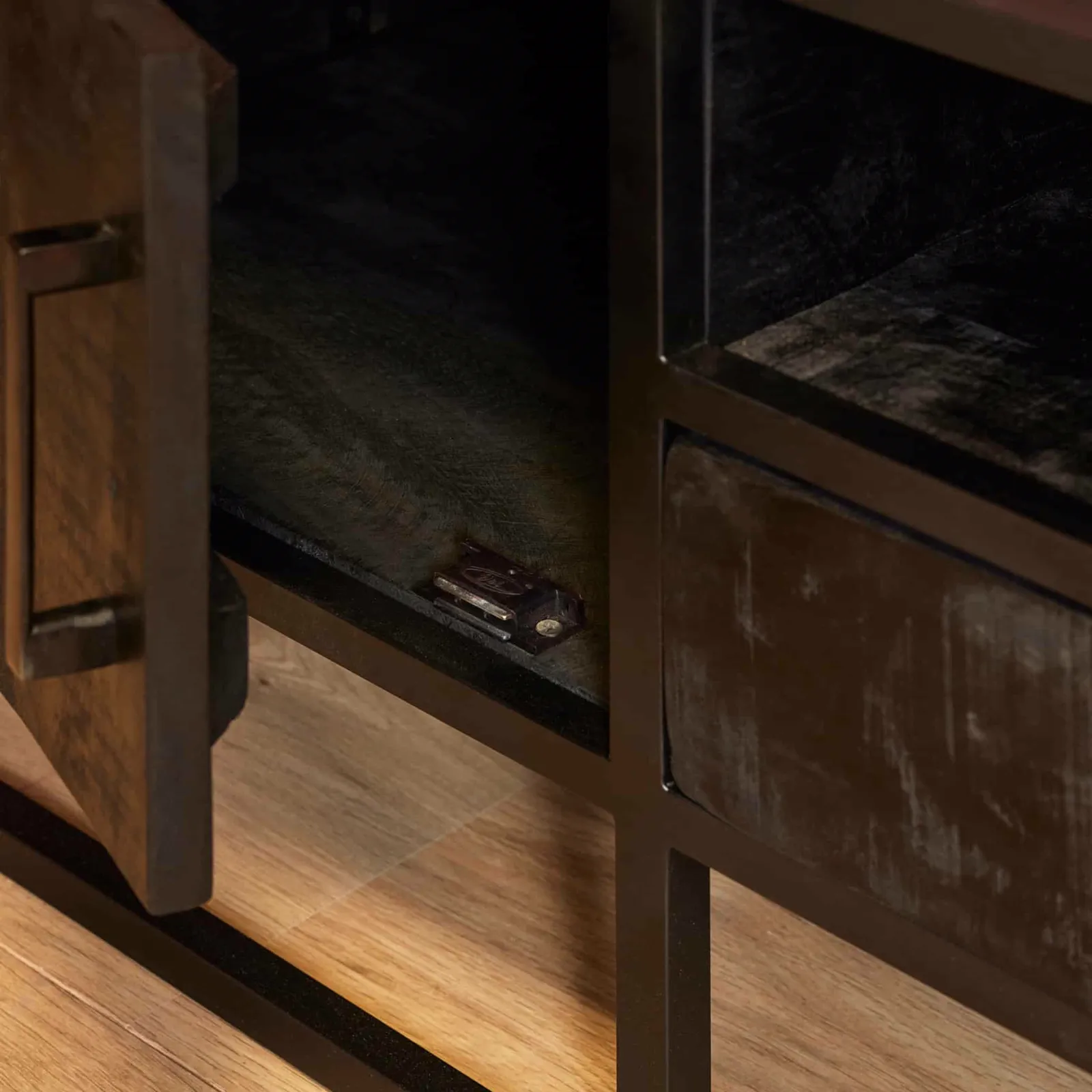 Detailaufnahme des TV Möbel Denver Black, mit einer geöffneten Schranktür, die ein Regal und einen kleinen Gegenstand zeigt - Starfurn