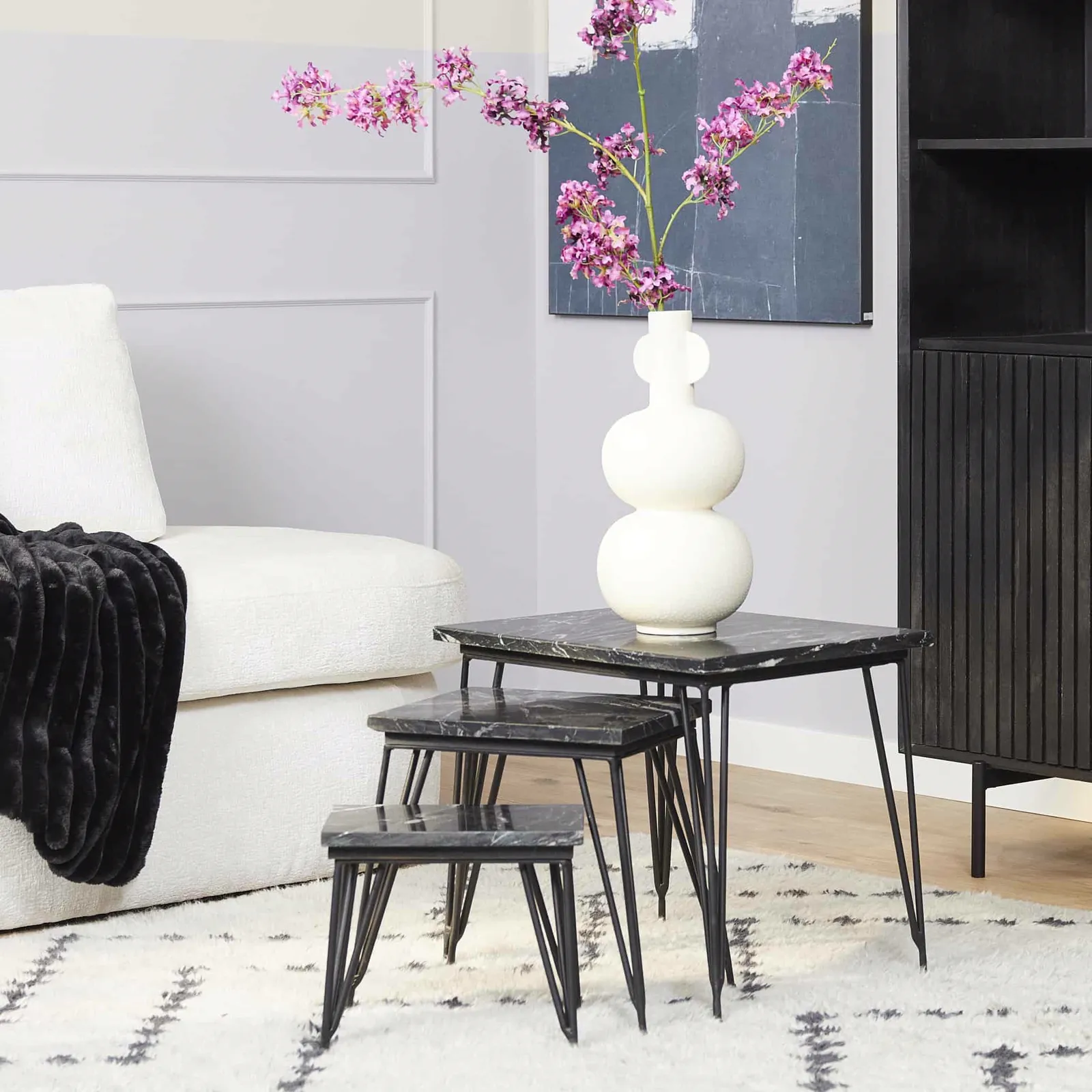 Die Couchtisch Jala Black marble 50 cm Set von 3 in einem hellen Wohnzimmer mit Sofa und Teppich - Starfurn