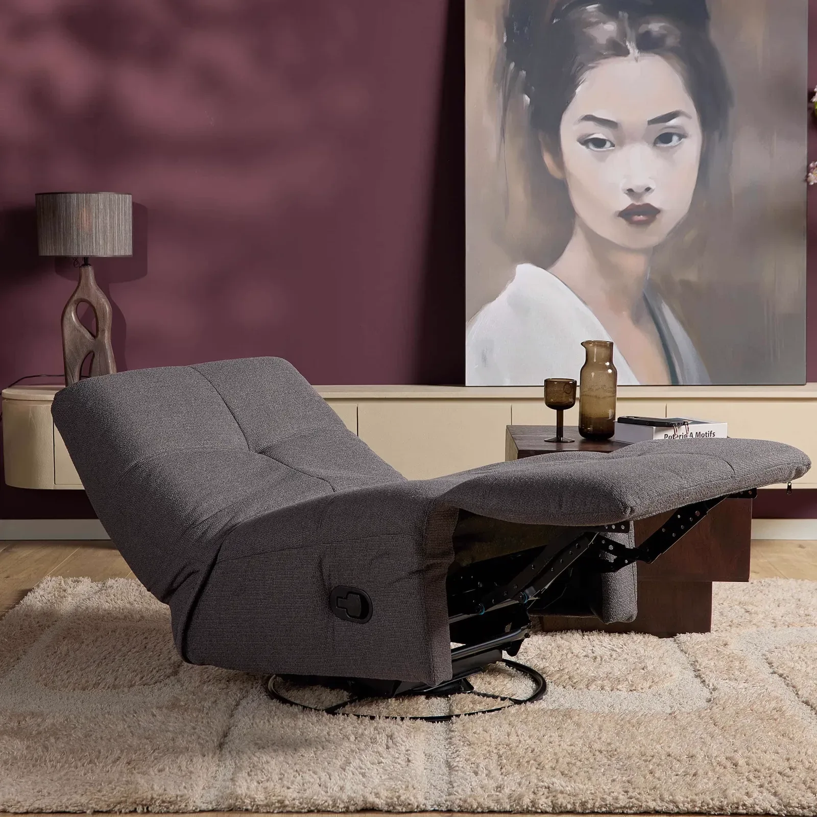 Der Relaxsessel Lazy in Dunkelgrau steht in einem Wohnzimmer mit violetter Wand und Kunst - Starfurn