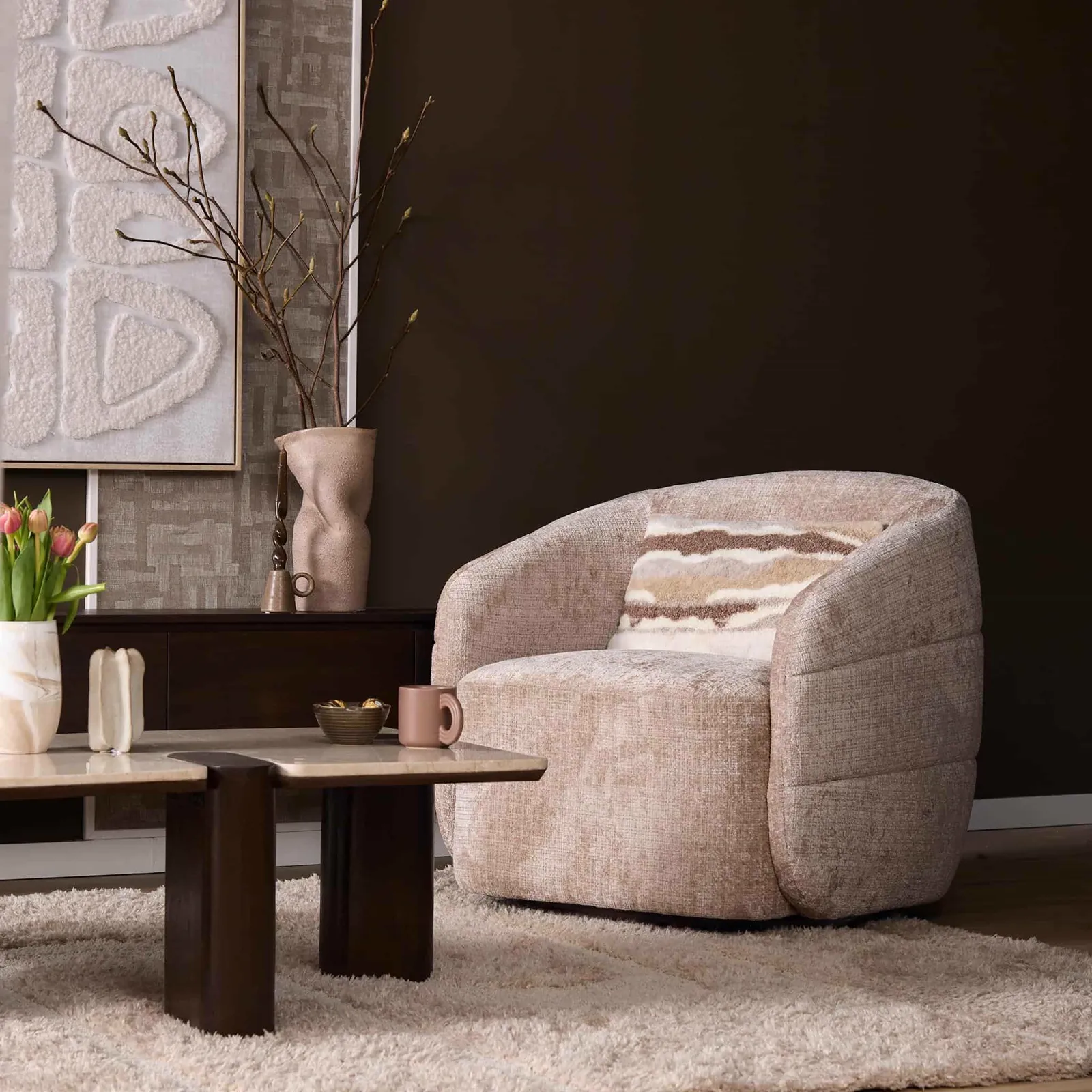 Der drehbare Sessel Yara Beige in einem stimmungsvollen Wohnzimmer mit Couchtisch und Dekoration - Starfurn