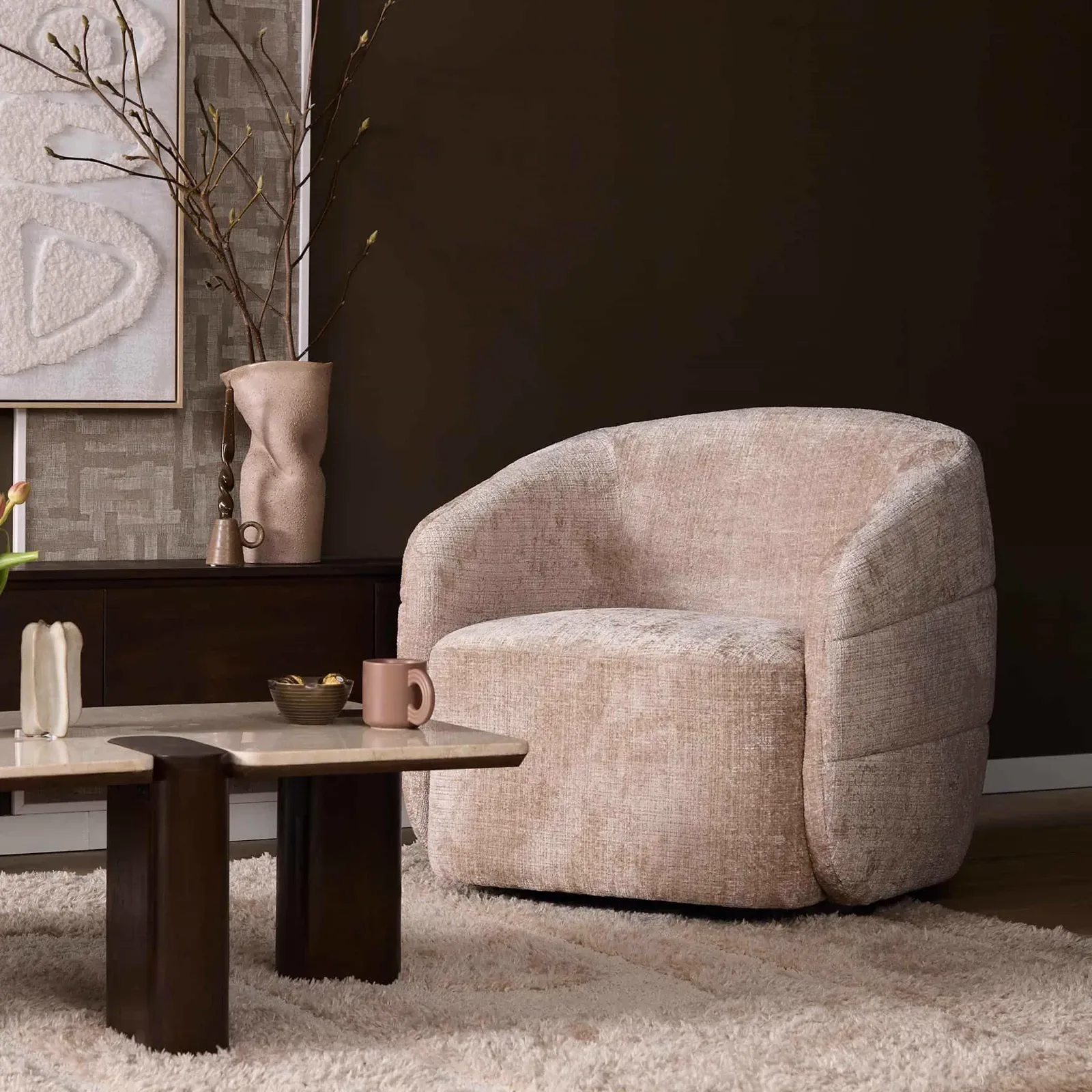 Drehbarer Sessel Yara Beige in einem stimmungsvollen Wohnzimmer mit Couchtisch und Teppich - Starfurn