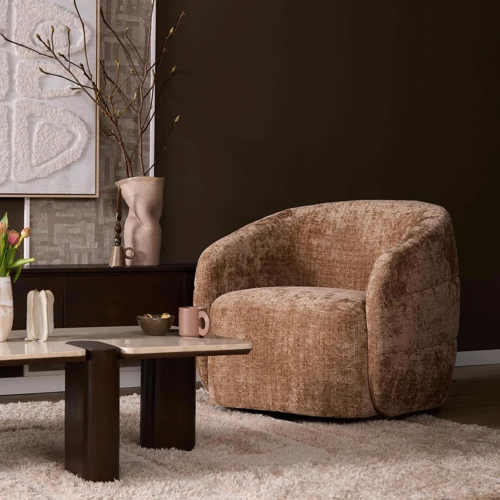 Drehbarer Sessel Yara Cinnamon in einem stimmungsvollen Wohnzimmer mit Couchtisch und Teppich - Starfurn