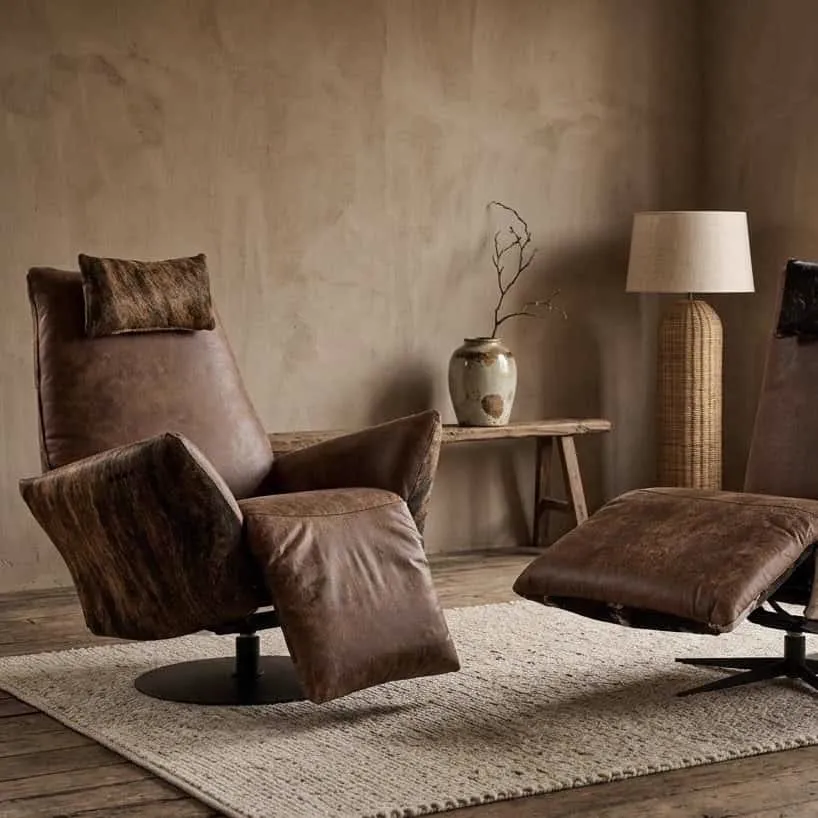 Relaxsessel Jesse Kuhfell Chill Line in einem stimmungsvollen Wohnzimmer mit Teppich und Lampe - Chill-Line
