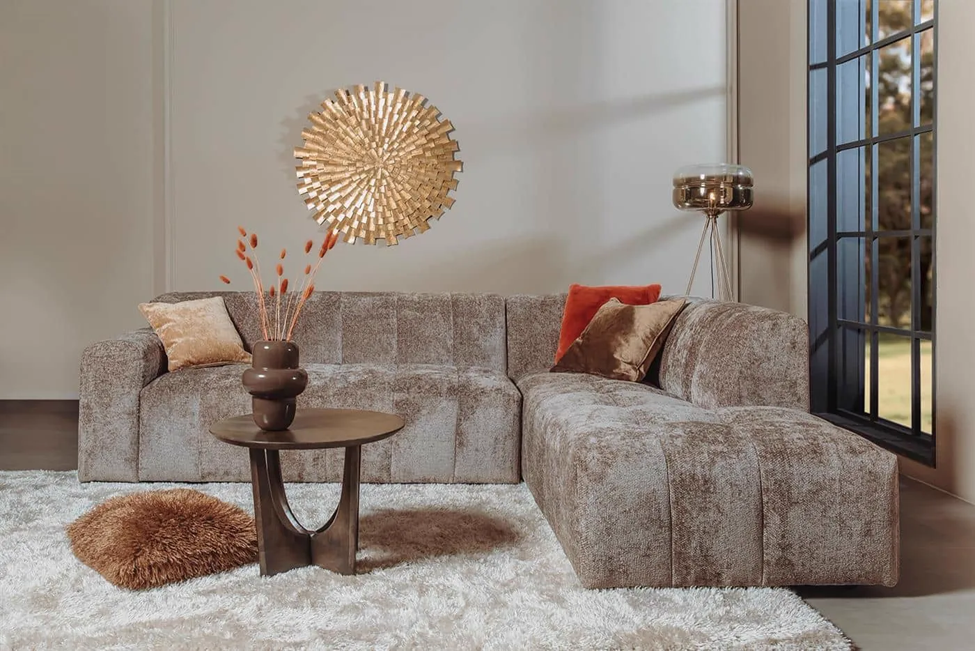 Das Austin 2 5-AL + Ottoman R - Haga 39 cappuccino Sofa in einem stimmungsvollen Wohnzimmer mit Couchtisch und Teppich - Tower Living