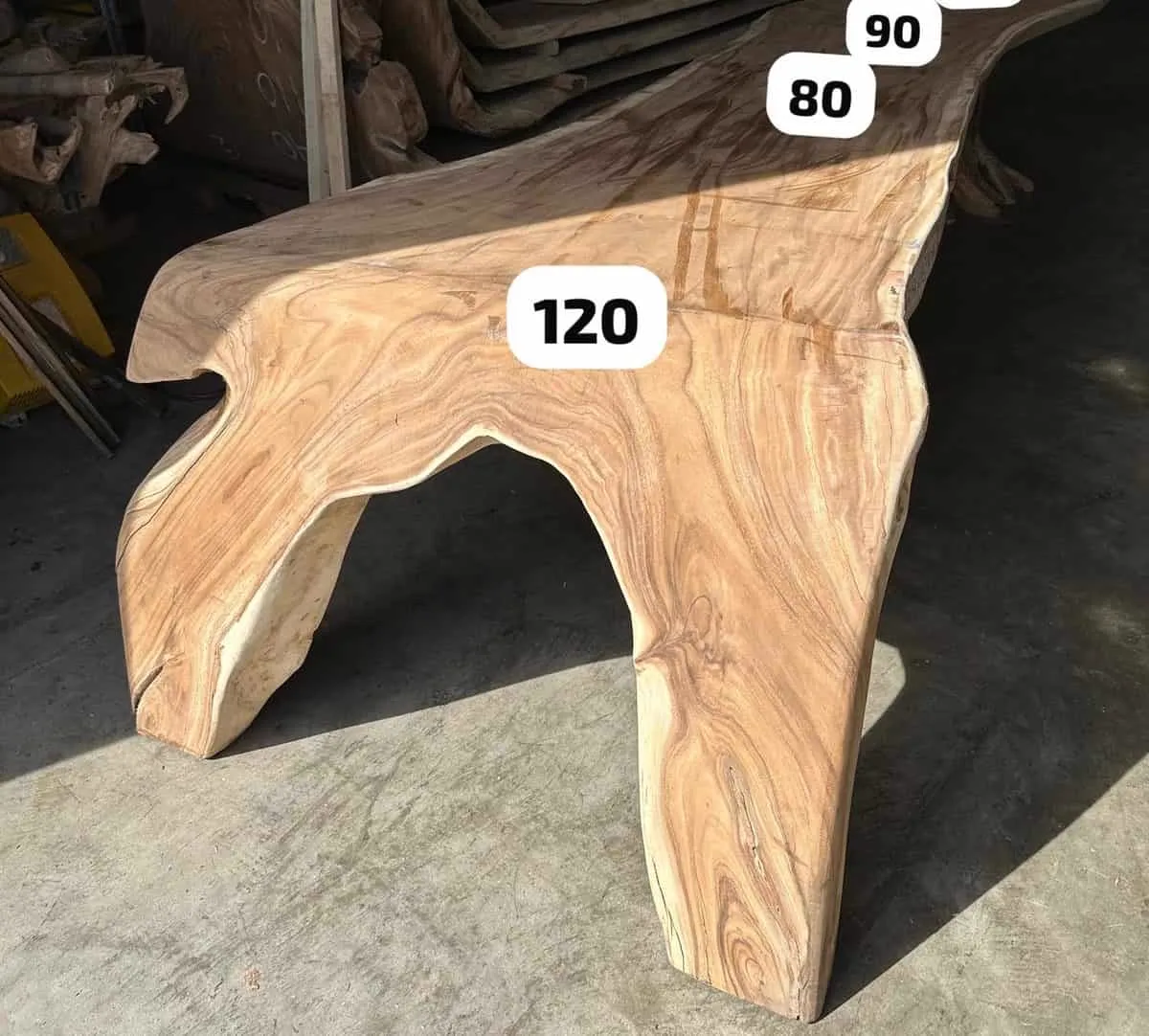 Nahaufnahme des Baumstammtisch Wasserfall Suarholz 340 cm, stehend auf einem Betonboden - World of Brosi