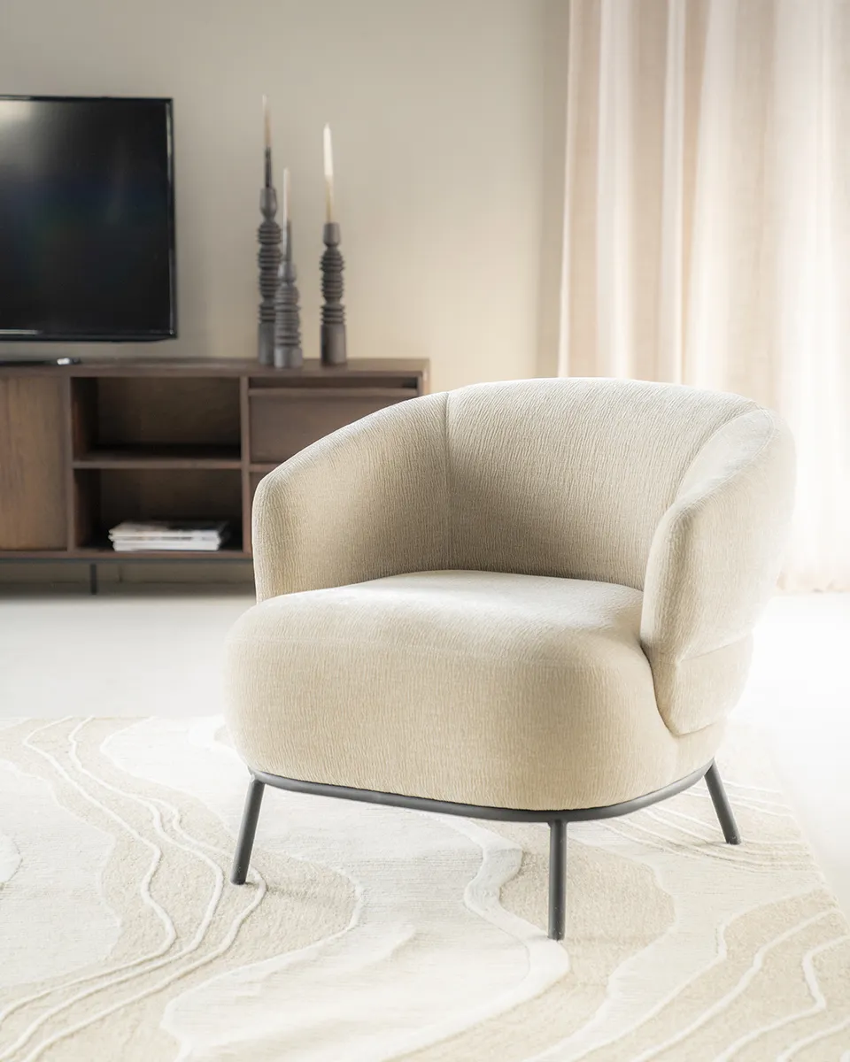 Sessel David Taupe Safari in einem hellen Wohnzimmer mit TV-Möbel und Teppich - Eleonora