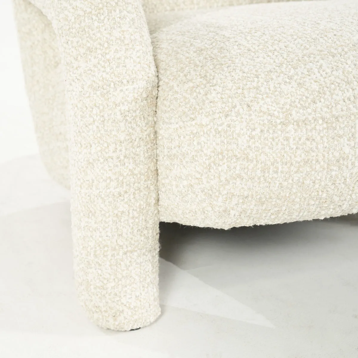 Detail des Sessels Monica - beige Asti, eine Nahaufnahme des beigefarbenen Bouclé-Stoffs und des Stuhlbeins - Eleonora