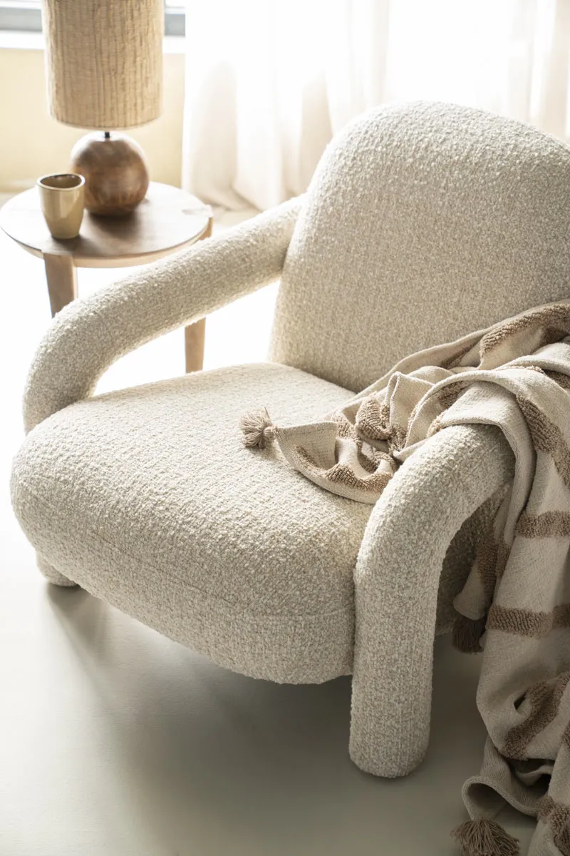 Sessel Monica in Taupe Asti Stoff, mit einem Plaid und Beistelltisch in einem hellen Wohnzimmer - Eleonora