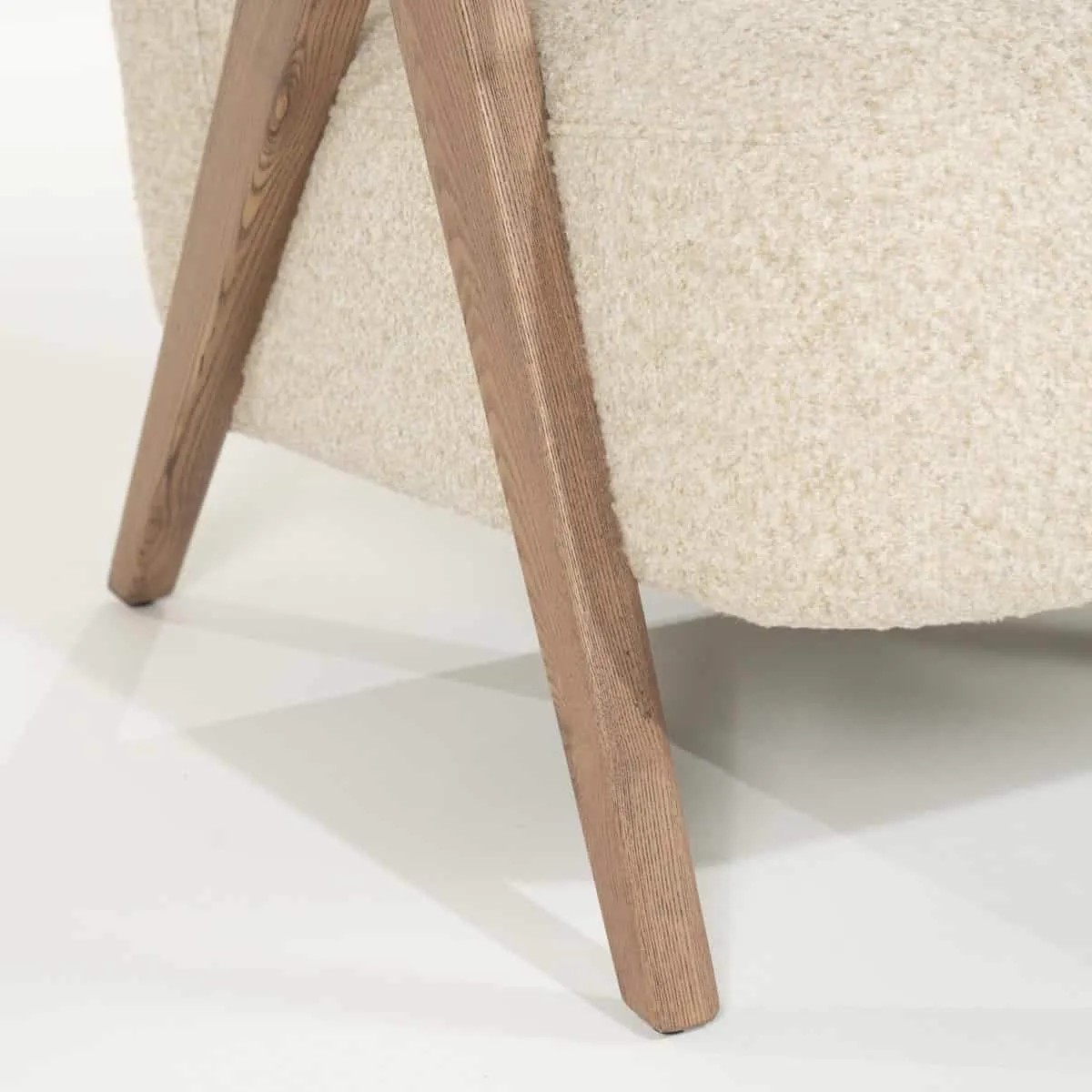 Detail des Sessels Francis - beige Flou mit einem schräg stehenden Holzbein auf weißem Hintergrund - Eleonora