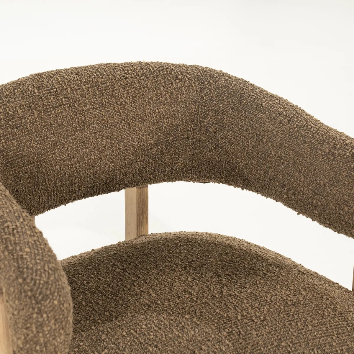 Detailaufnahme des braunen Bouclé-Stoffs des Sessels Lola, mit einem sichtbaren Holzrahmen - Eleonora