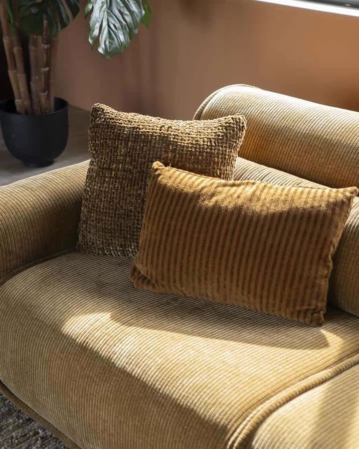 Kissen Sirun Terrakotta auf einem gerippten Sofa, mit einem weiteren Kissen und Pflanze in gemütlicher Umgebung - By-Boo