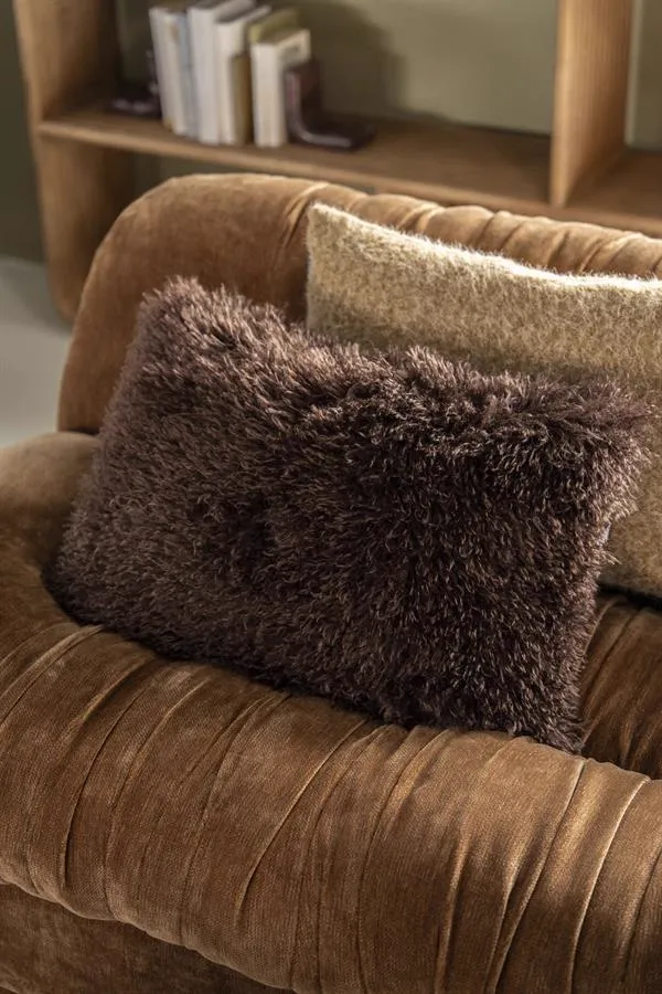 Das Kissen Doodly dunkelbraun liegt auf einem braunen, gerafften Sofa, mit einem hellen Kissen dahinter - By-Boo