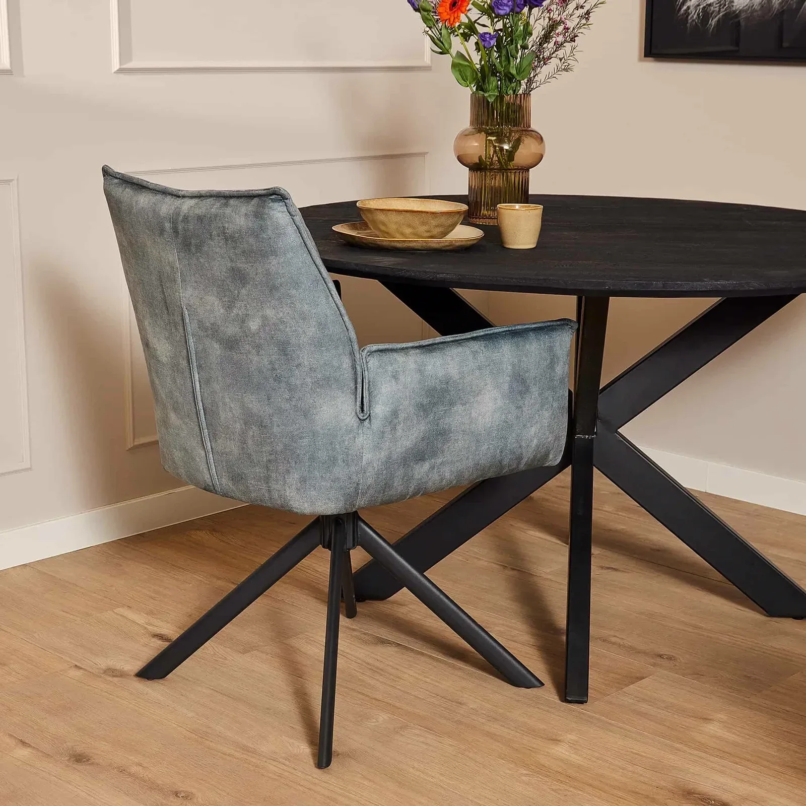 Esszimmerstuhl Dani drehbar Blau Velvet an einem dunklen Esstisch in einem Interieur - Starfurn