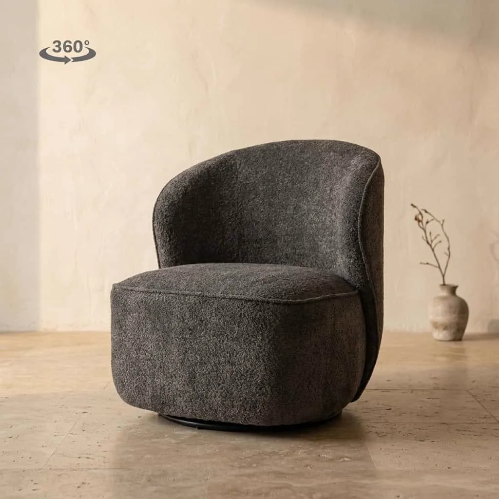 Der drehbare Belvi Sessel aus dunkelgrauem Stoff in einem Studio mit hellen Wänden und Boden - Tower Living