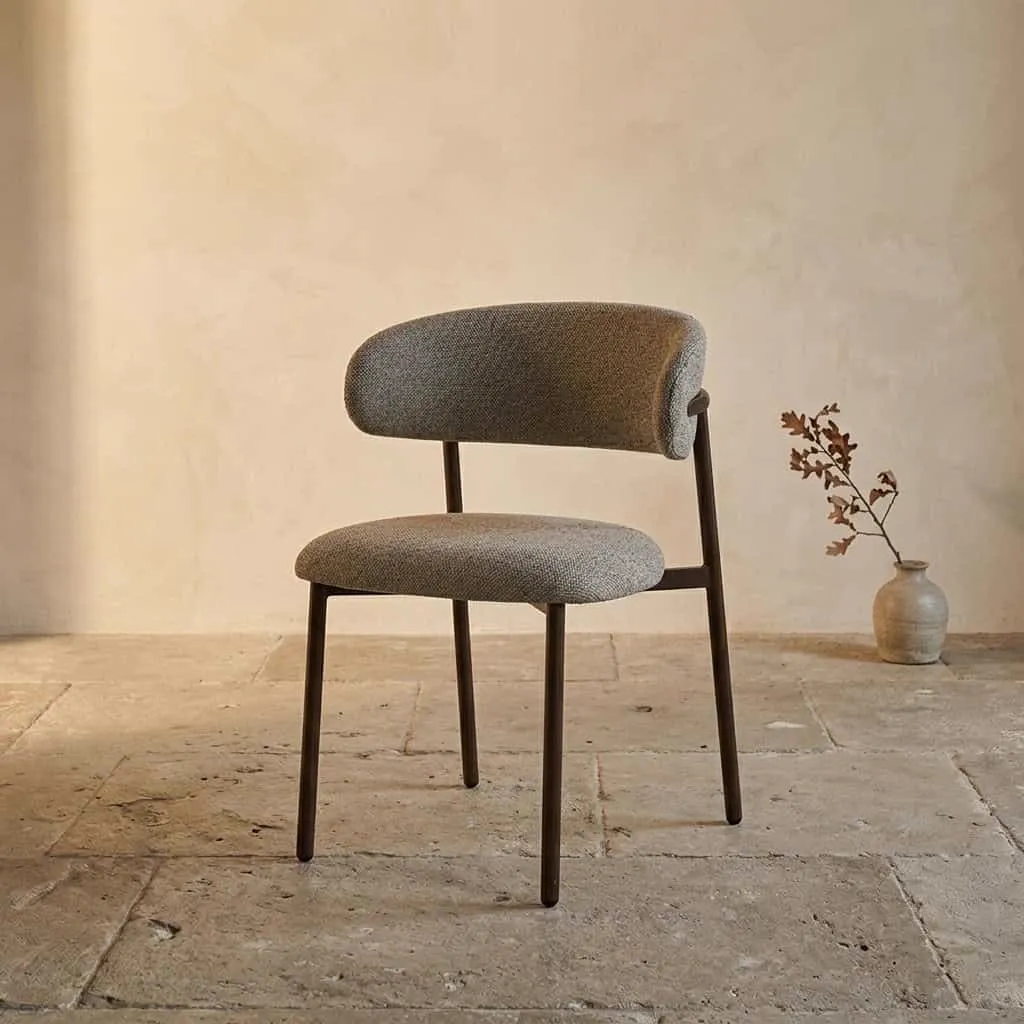 Esszimmerstuhl Micah Hush Walnut in einer Studio-Umgebung mit einer Vase und einem Zweig daneben - Livingfurn