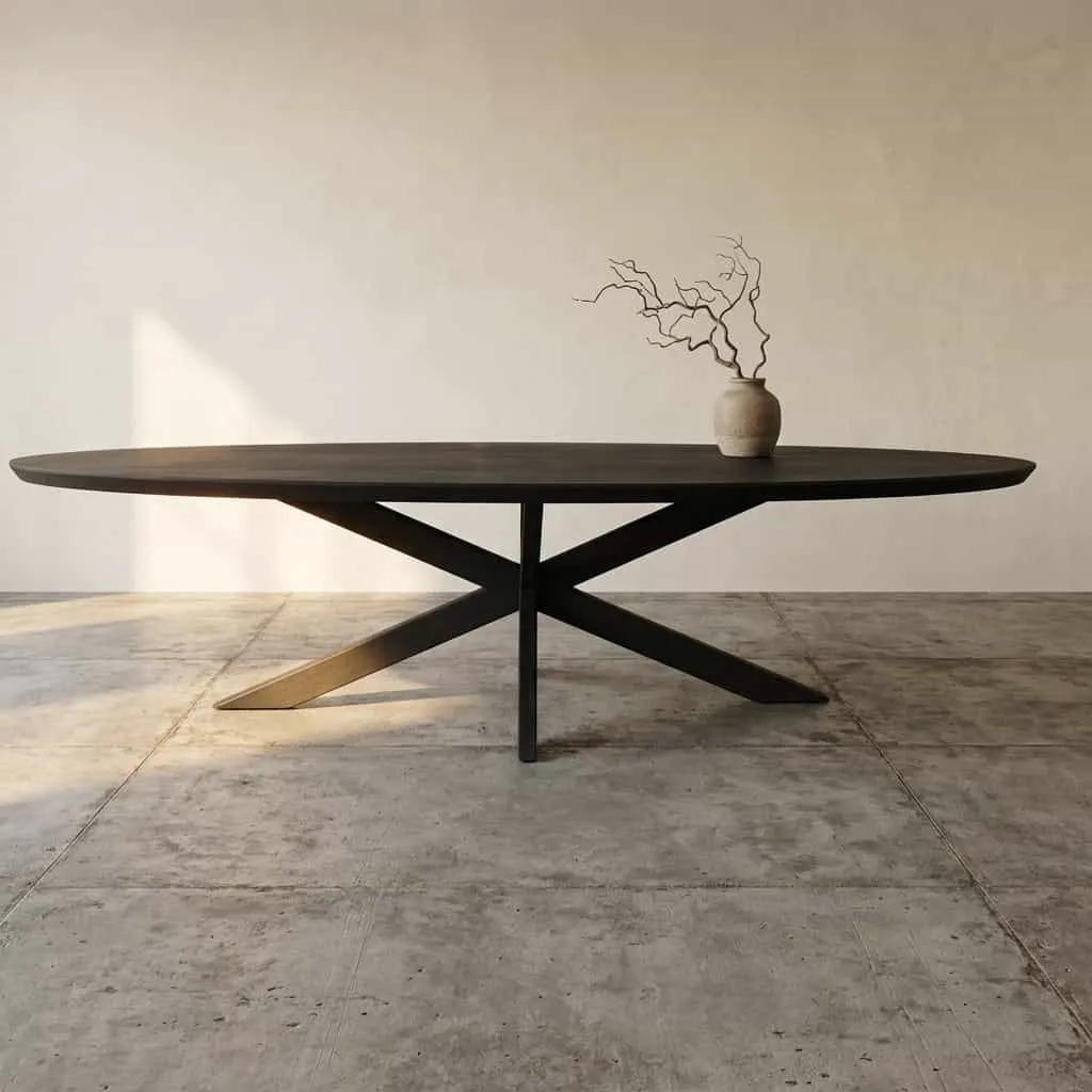 Der ovale Esstisch Brandy Black 240 cm in einem minimalistischen Studio mit Betonboden und Vase mit Ästen - Starfurn