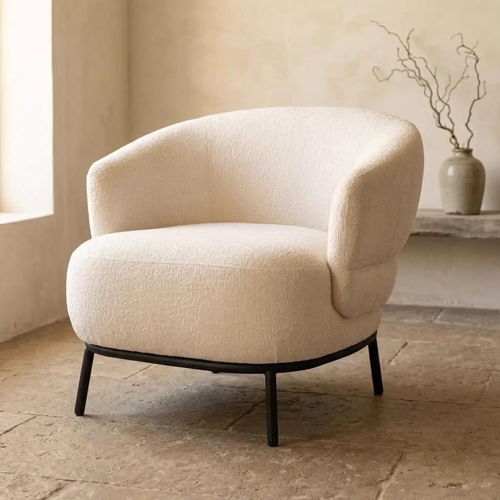 Sessel David Beige Safari in einem hellen Wohnzimmer mit einer Vase mit Ästen auf einem Regal - Eleonora