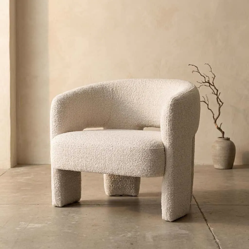Sessel Hamilton - Beige Asti, ein moderner Sessel mit abgerundeten Formen in einem hellen Studio - Eleonora