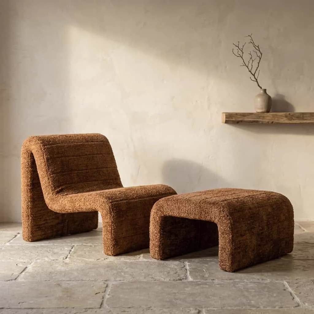Loungesessel Kelly Lovely Cinnamon und passender Hocker in einem stimmungsvollen Studio mit heller Wand und Steinboden - Richmond Interiors